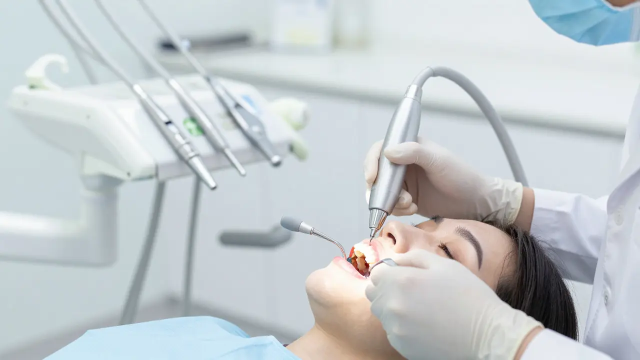 Zubní lékař provádí profesionální čištění zubů ultrazvukem